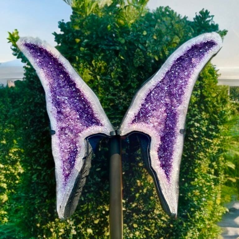 Large amethyst geode on white stone surface