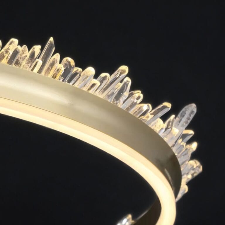 Close-up of modern circular chandelier with crystal spikes illuminated against dark background