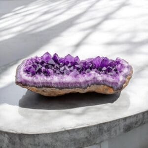 Large amethyst crystal geode displayed on a marble surface